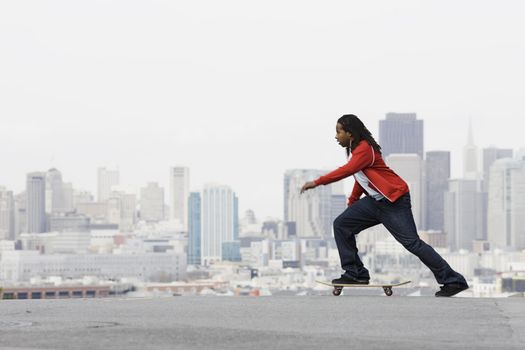 African American Teen Boy on Skateboard in front of City View