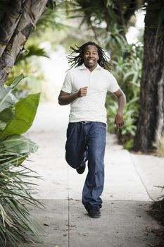 African American Teenage Boy Running on Sidewalk