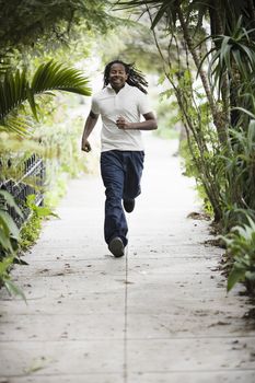 African American Teenage Boy Running on Sidewalk