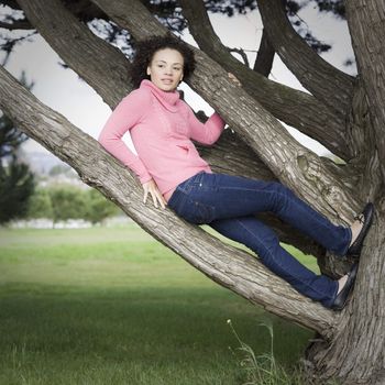 Mixed-Race Woman in Pink Sweater Sittting on Tree Branch