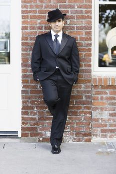 Man Wearing a Black Suit and Tie  Standing against Buliding