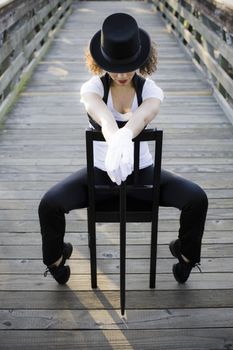 Jazz Dancer with Head Down Sitting on Chair on Bridge