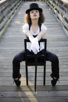 Jazz Dancer in Tophat Sitting in Chair on Bridge