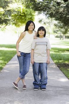 Asian Brother and Sister Standing in a Park