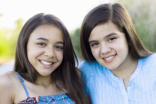 Two Tween Girls in a Park Smiling To Camera