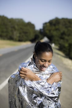 Woman in Space Blanket on Side of Road