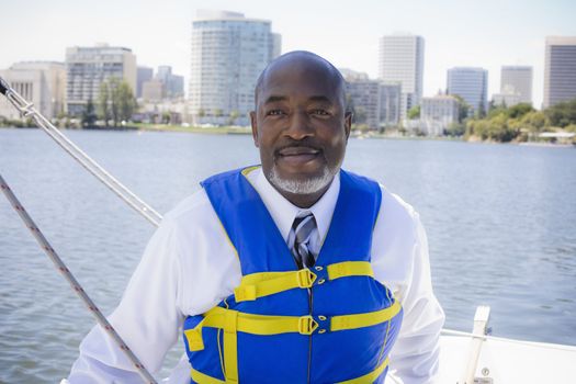 African American Man in Life Vest Sailing a Boat