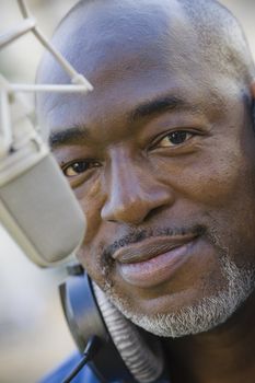 African American Man With headphones around neck and Microphone