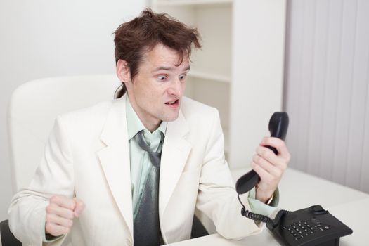 The person emotionally communicates with phone at office