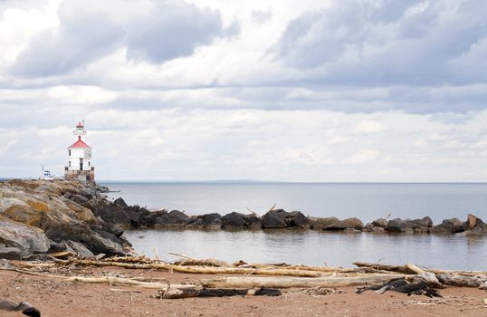 Lighthouse at end of rocky pier along Lake Superior