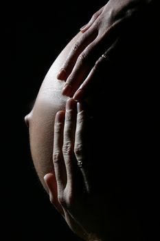 Two hands are giving warmth to unborn baby.