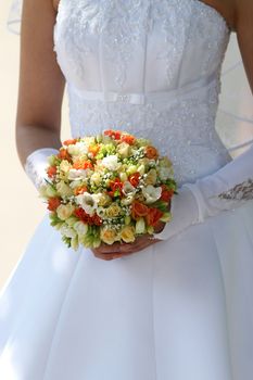 Multi-coloured bouquet in the hands of bride.