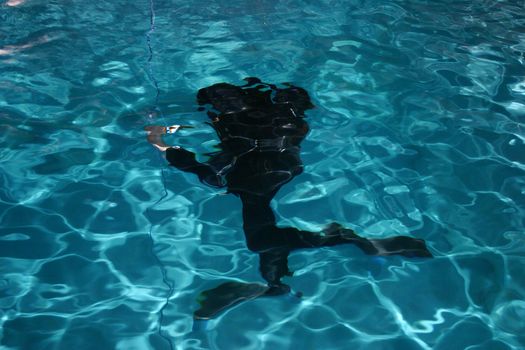 Diver moving underwater with lamp in his hand.
