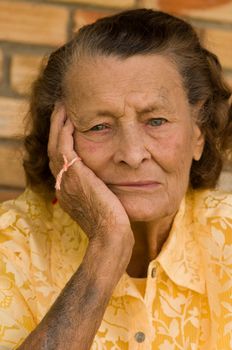 vertical of senior caucasian woman with head in hand and string on fingers wondering what she forget