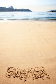 The word summer written in the sand at a beach