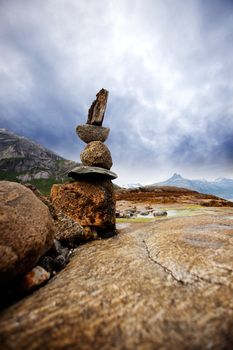 A rock stacking sculpture statue on a Norwegian landscape