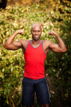 A male flexing his biceps - isolated against a green 