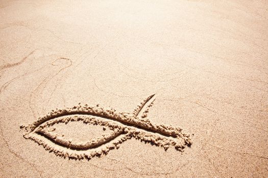 A fish symbol in drawn in the sand