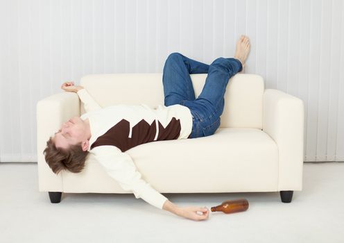 The drunkard sleeps on the sofa in an amusing pose