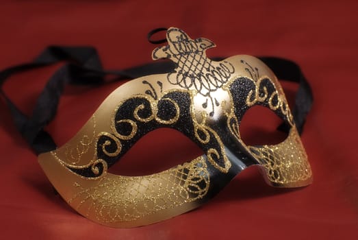 Closeup of a venetian mask commonly used in theatrical plays shot on red 