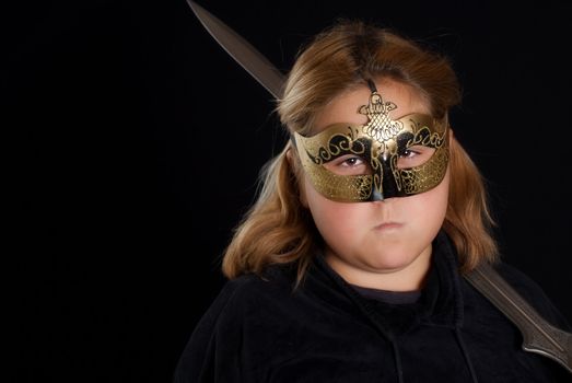 Closeup view of a young warrior princess holding her sword, shot against a black background with copyspace on the left