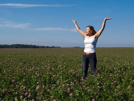 Beautiful attractive young happy woman girl in a sunny flowers field