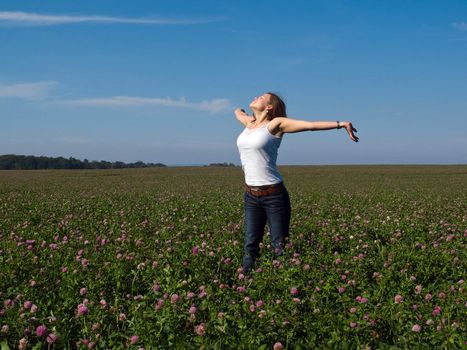 Beautiful attractive young happy woman girl in a flowers field