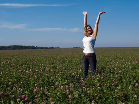 Beautiful attractive young happy woman girl in a sunny flowers field