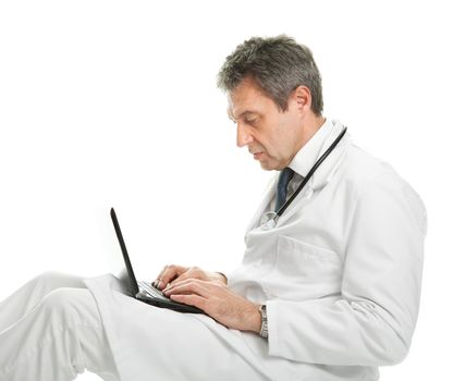 Medical doctor sitting and working on laptop. Isolated on white