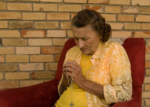 elderly caucasian woman with hands folded in prayer