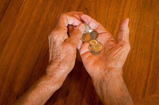 senior hands holding coins