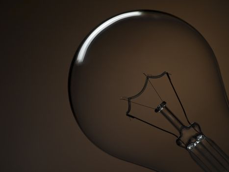 Close up on a transparent light bulb over a brown background.