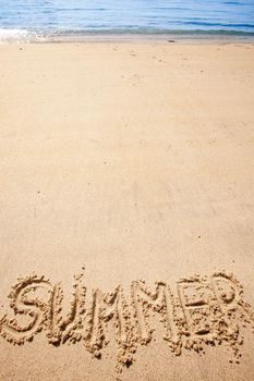 The word summer written in the sand at a beach