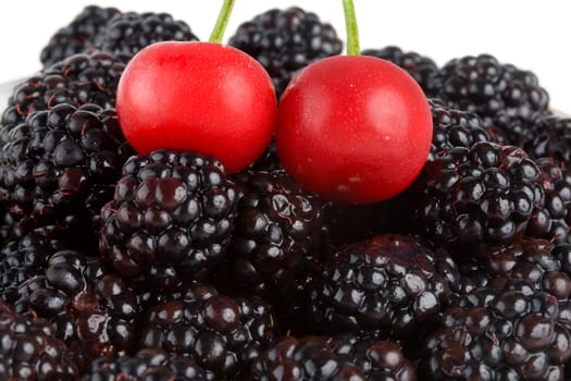 close-up two ripe cherry and blackberries