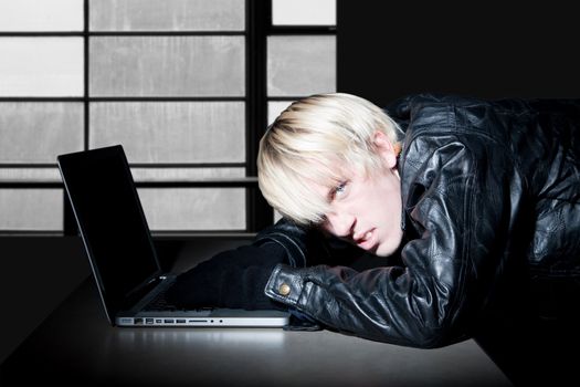 Computer criminal hacking on a laptop in secret location