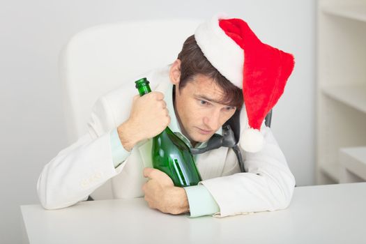 The young guy in a Christmas cap with a bottle