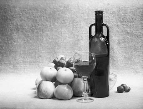 Black and white still-life with wine and fruit on a sacking