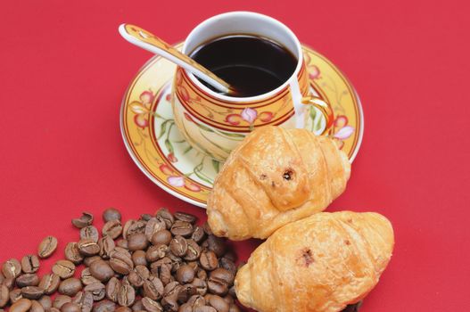 Heap of coffee bean and the cup on a red background