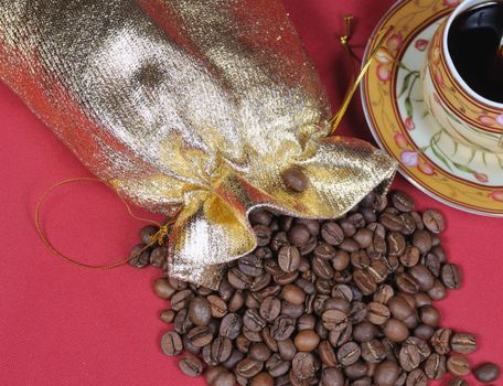 Heap of coffee bean and the cup on a red background