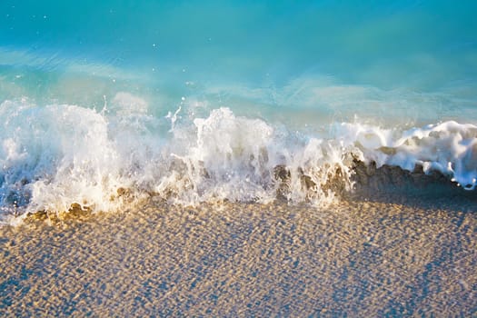 Small sea waves ending in the sand