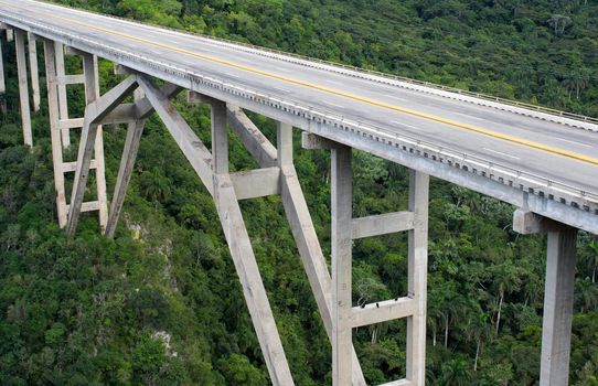 Tall bridge crossing a green tropical valley