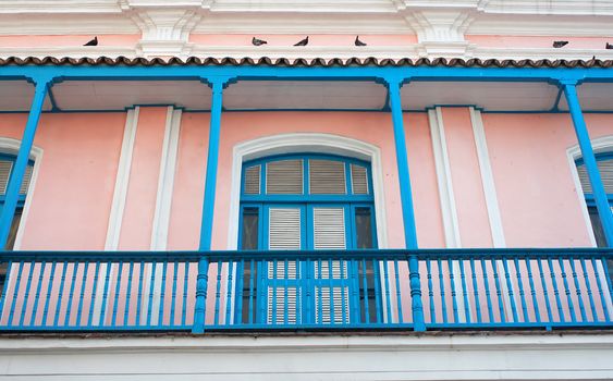 Old colorfulpink and blue  balcony with pigeons