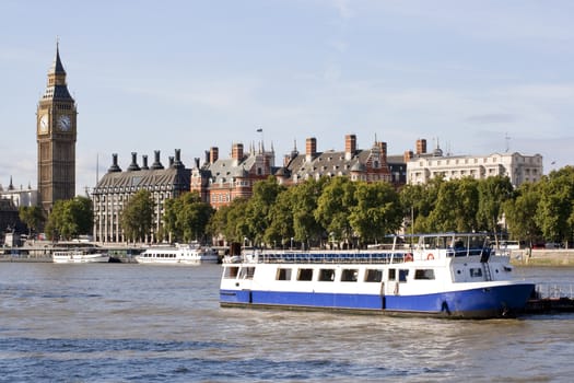 View of The Big Ben, houses and a boat in the river Thames in London