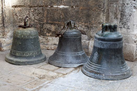 Three old bronze bells standing in the floor