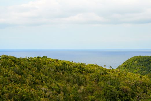 View of a green valley with the sea in the horizon