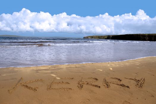 kerry inscribed on the beach with ocean waves and a cliffs in the background