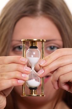 The nice girl having control over a sand-glass removed close up