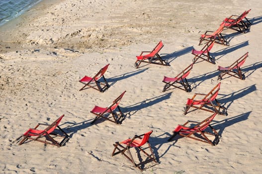 Longe chairs on empty sandy sea beach