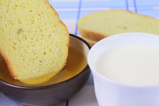 Cornbread with honey and milk on a blue woven napkin removed close up