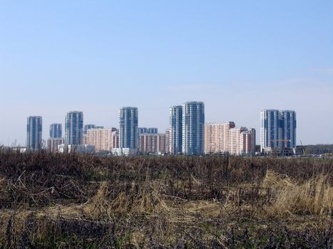 New urban city with high houses, view from the field